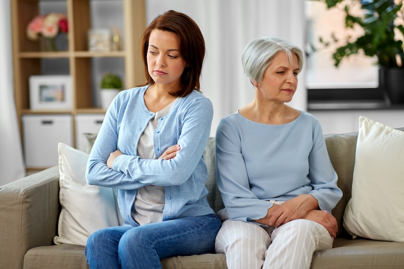 Mutter und Tochter sitzen auf dem Sofa und haben einen Konflikt