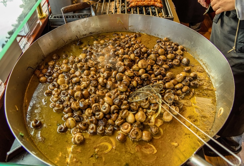 Große Pfanne mit Pilzen auf dem Weihnachtsmarkt