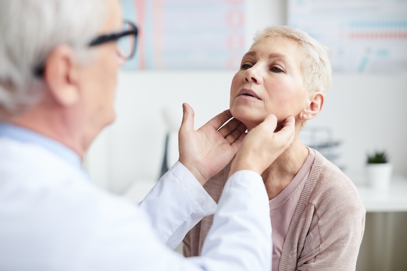 Arzt tastet Lymphknoten einer Frau